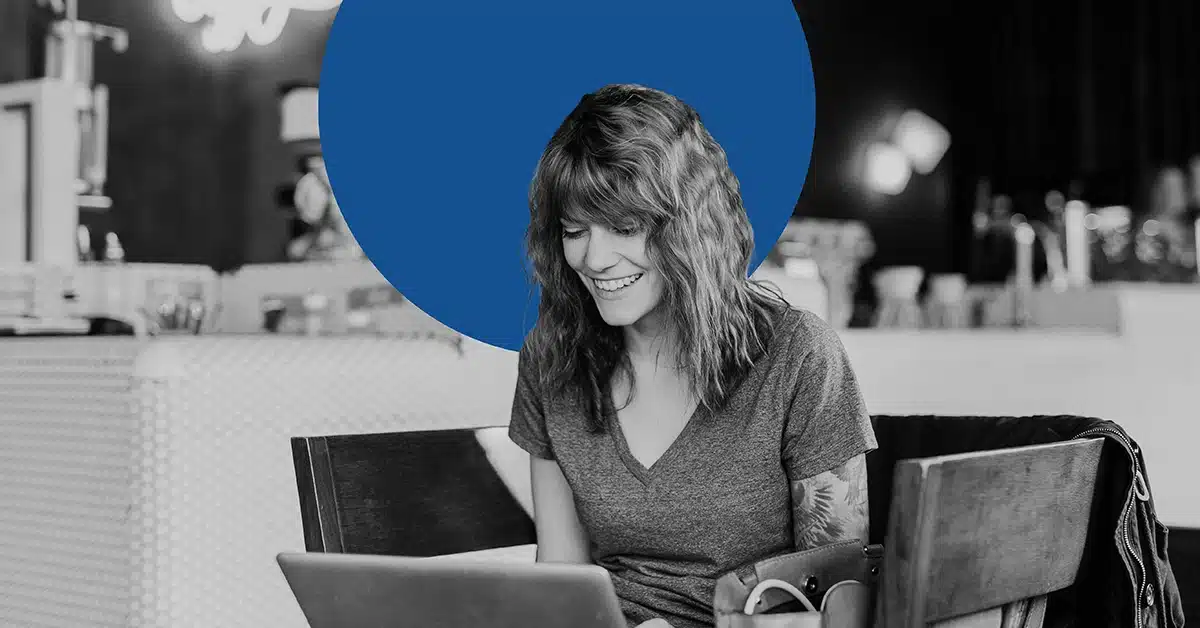 Woman smiling during a micro-moment as she works on her laptop.