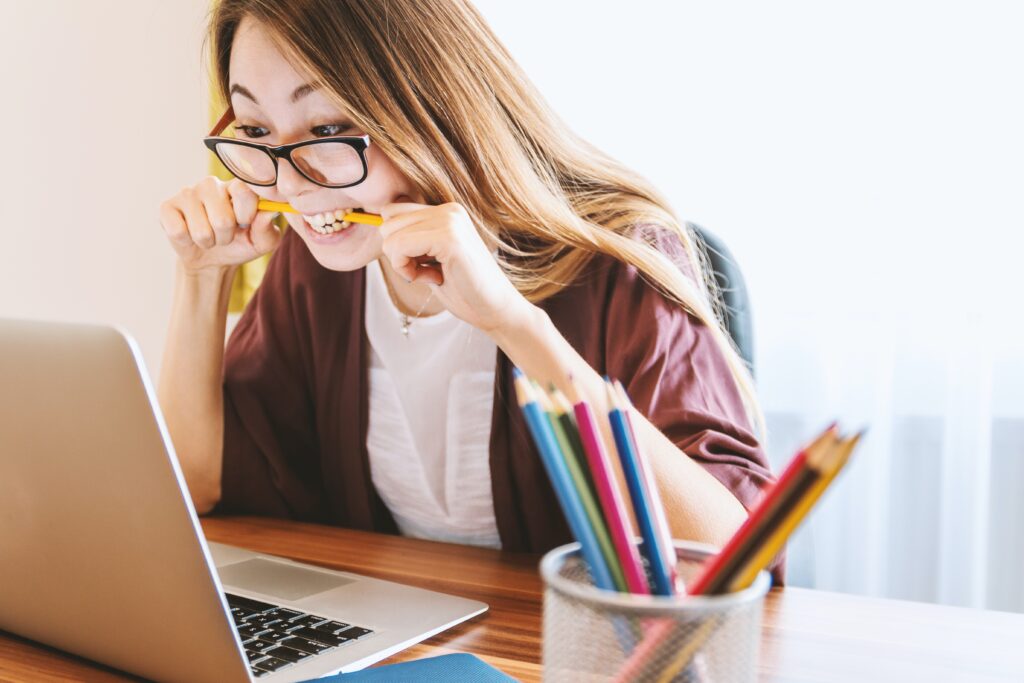 An email marketer at her desk chews a pencil in frustration while dealing with email soft bounces.