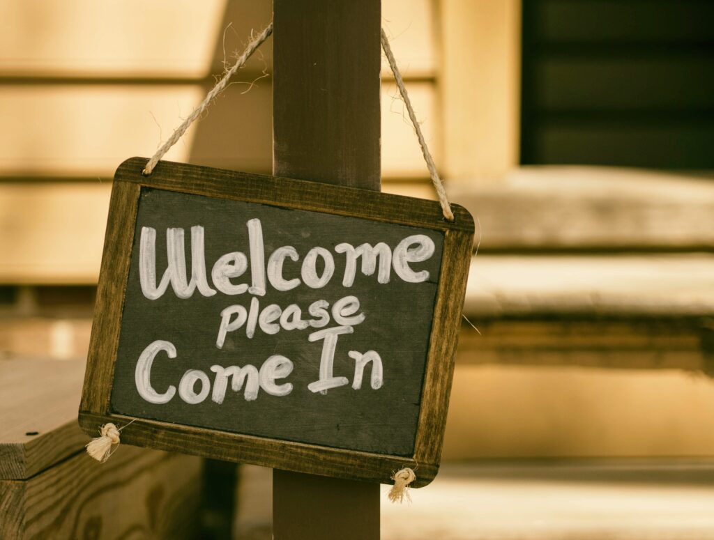 A rustic sign reads "Welcome Please Come In" 