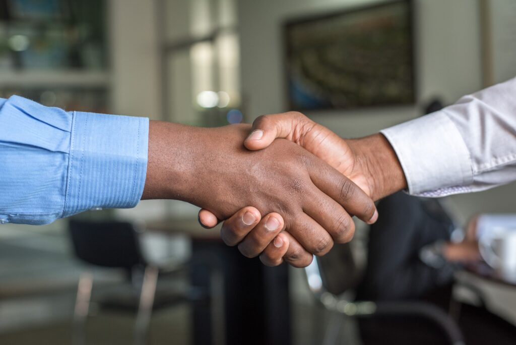 A salesperson shakes hands as he closes a deal with a perspective customer