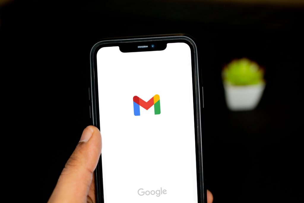 A mobile phone displays the Gmail home screen.