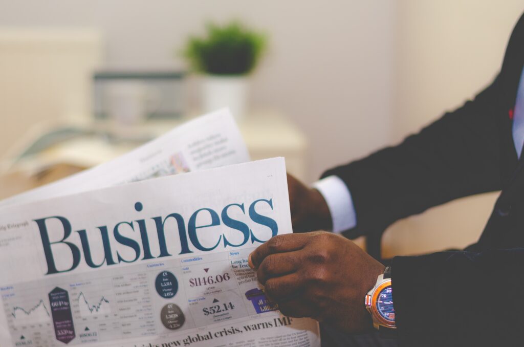 Close up of the hands of a black executive reading the business section of a newspaper to illustrate ABM tactics.
