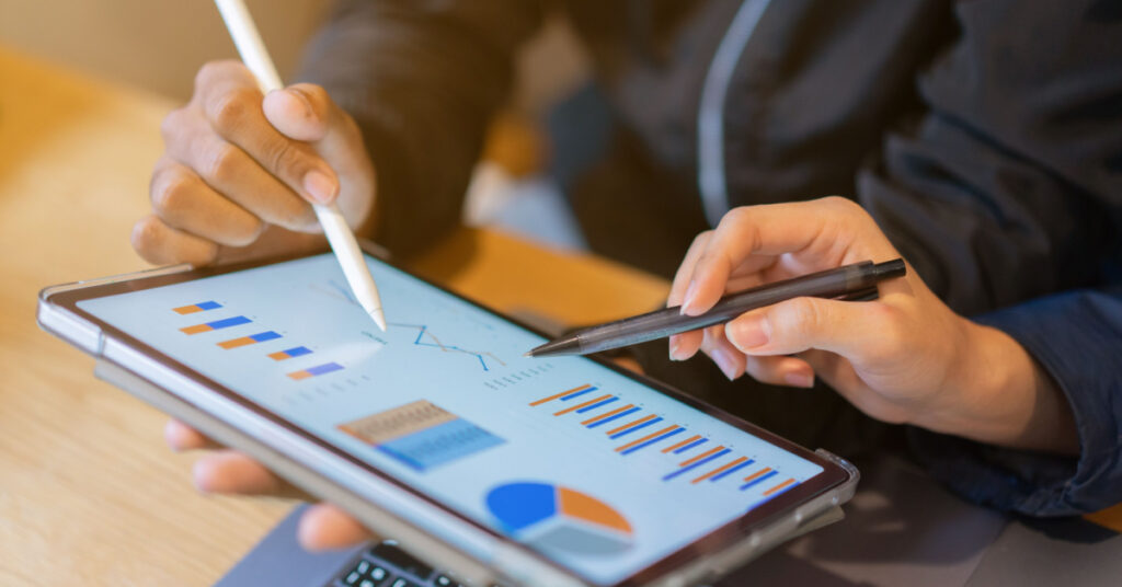 closeup of hands interacting with marketing metrics like customer lifetime value on a tablet