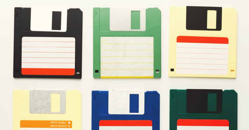 Old floppy disks isolated on white background. Top view of magnetic retro storage devices, colorful diskettes.
