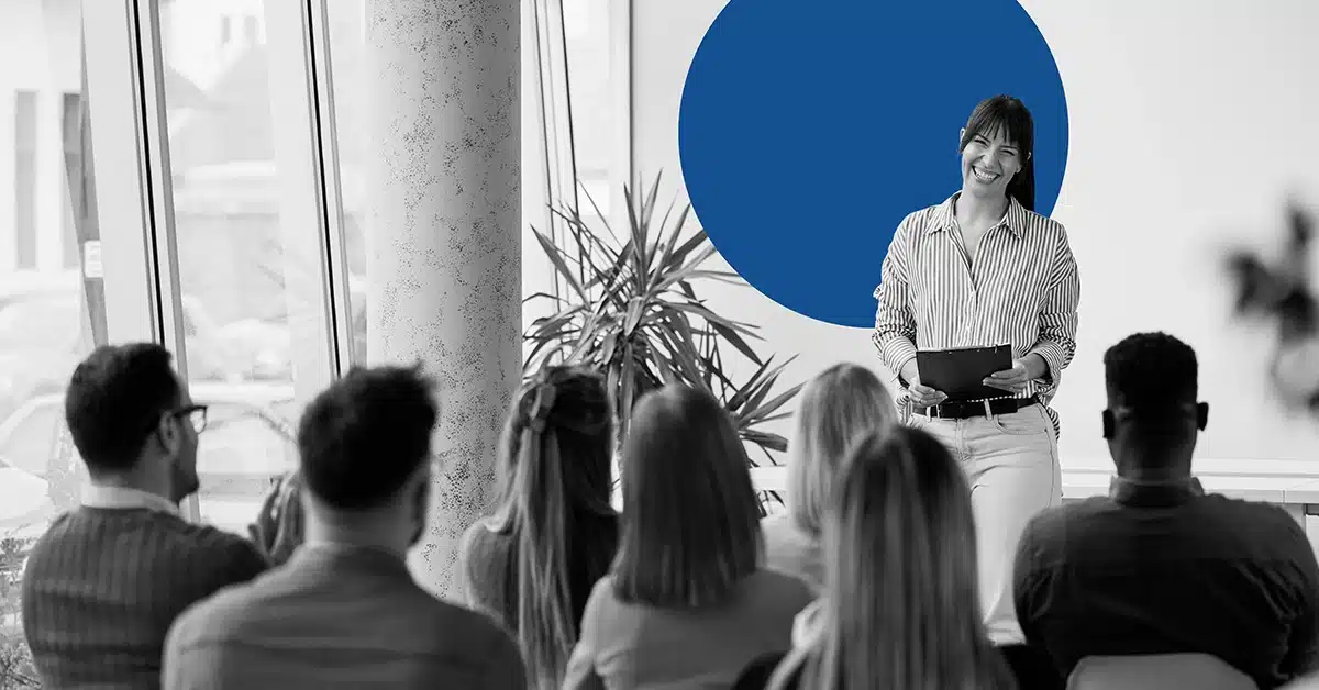 Woman presenting during a marketing conference to a small group of people.