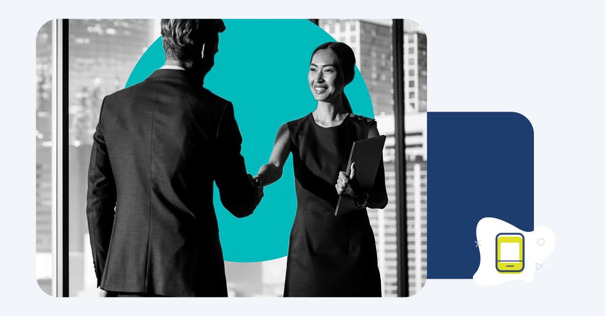 Man and woman shaking hands in an office building.