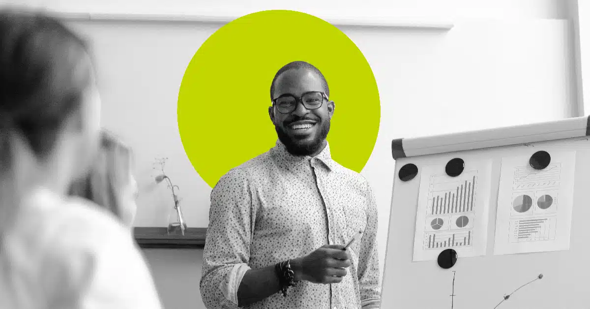 a man stands at a whiteboard for a sales pitch illustrating the idea of how to upsell effectively