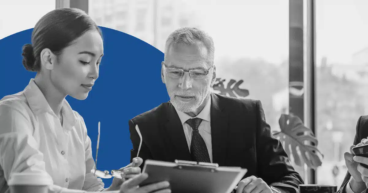a senior and junior professional collaborate on a document to illustrate internal marketing automation