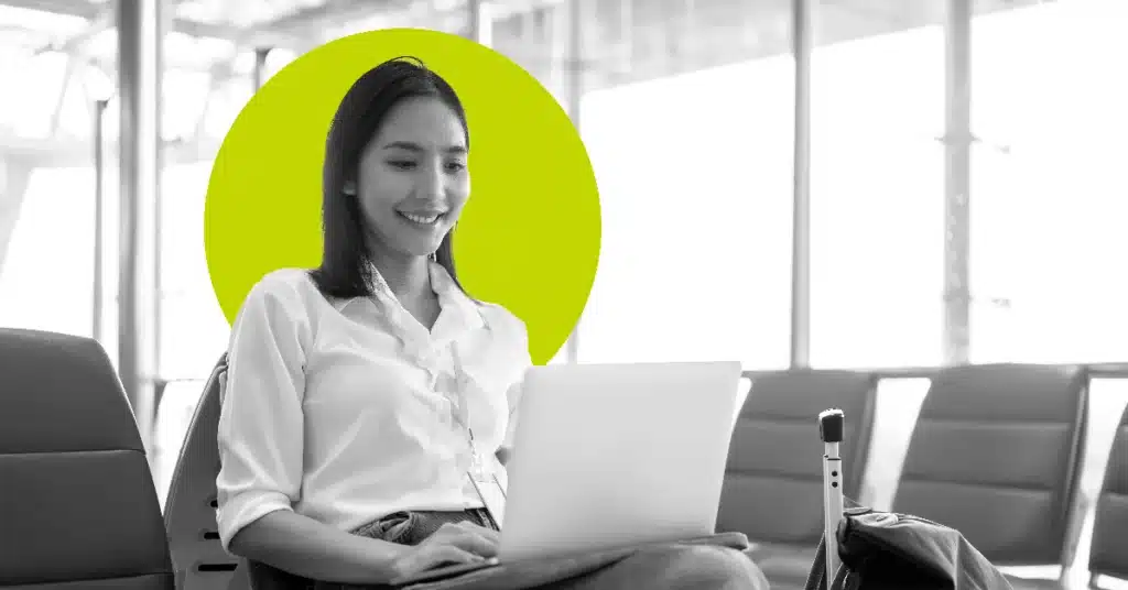 a woman in an airport works on a laptop in a black and white image accented with yellow